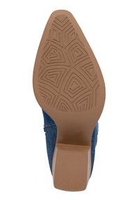 Base de zapato de tacón de denim con suela de goma marrón, que presenta un patrón de tracción geométrica y un acabado ligeramente texturizado.