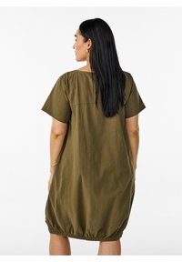 Olive zelené šaty s krátkymi rukávmi, vo voľnom strihu, s okrúhlym výstrihom a elastickým spodným okrajom. Vyrobené z ľahkého materiálu.