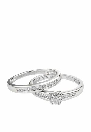 Zwei ineinandergreifende Ringe aus poliertem Weißgold; einer hat einen zentralen runden Diamanten und kanalförmig gefasste Diamanten entlang des Ringschafts.