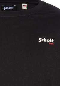 T-shirt in cotone nero a maniche corte, con scollo rotondo. Logo ricamato in bianco e rosso "Schott N.Y.C" ben visibile sul davanti. Etichetta di taglia 14 visibile.