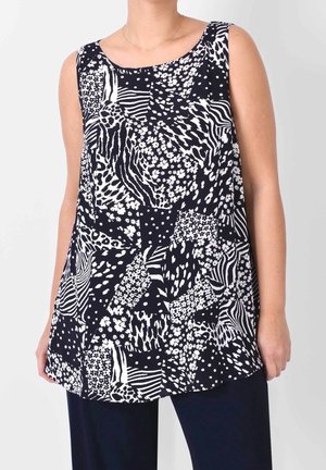 Ärmelloses schwarz-weiß gemustertes Oberteil mit gemischten Tier- und Blumenmotiven, getragen zu dunkler Hose.