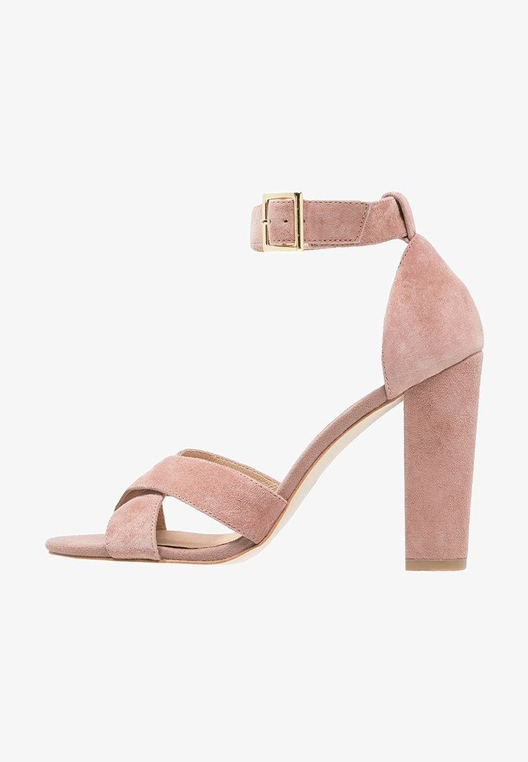 Rosa mocka högklackad sandal med korsade tåremmar, vristrem och guldspänne, med en blockklack.