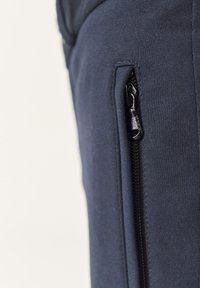 Navy blauwe broek met een slim fit, een gladde textuur en een zijzak met een zwarte ritssluiting voor veilige opslag.
