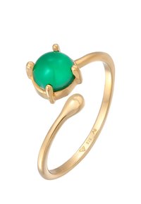 Anello d'oro con una gemma verde rotonda, banda d'oro liscia con una leggera torsione e quattro griffe che tengono saldamente la pietra.