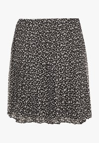 Musta hame, jossa on kevyt ja laskeutuva kangas valkoisella kukkakuviolla. Pliseerattu malli, säädettävä vyötärö ja helma ylettyy reiden keskikohdalle.