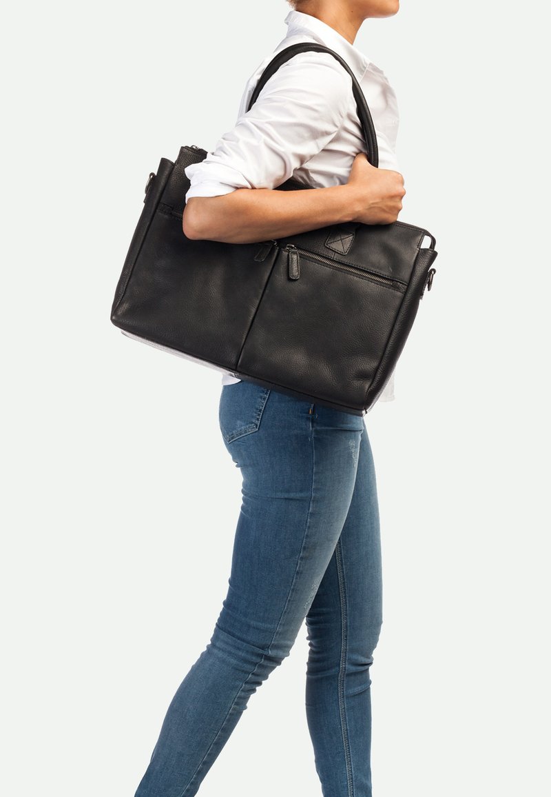 Bolso tote de piel negra con dos asas superiores, cierre de cremallera y bolsillos exteriores, con un acabado texturizado y forma estructurada.