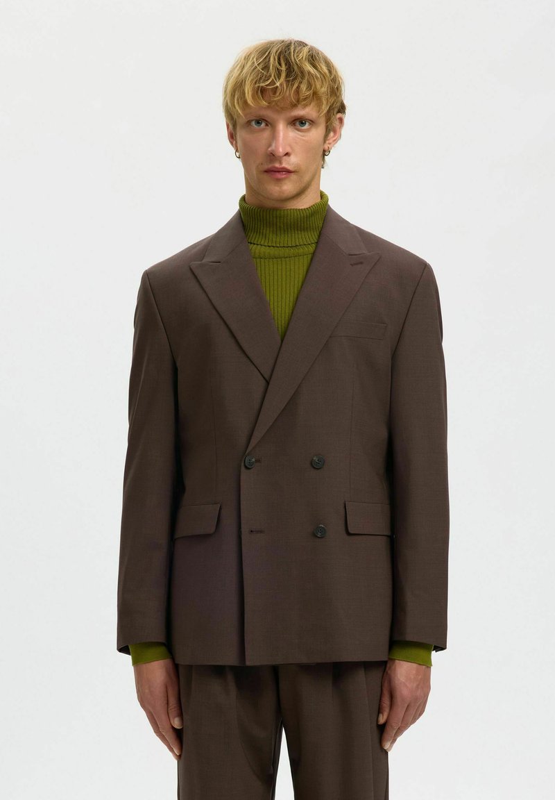 Pruun kaherealine bleiser notšiga kraedega, mustade nuppude, küljetaskute ja all roheline soonikkoega kõrge kaelusega kampsun.