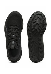Des chaussures de sport noires avec une tige en tricot texturé, un bout arrondi et une semelle extérieure en caoutchouc robuste avec un motif de traction.