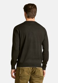 Maglione nero lavorato a maglia con maniche lunghe e collo rotondo, caratterizzato da un design pulito e orlo a coste, indossato con pantaloni cargo verde oliva.