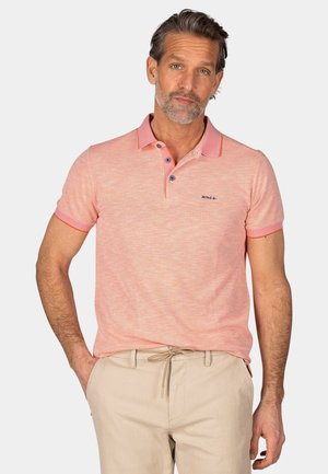 Polo-shirt in licht koraal met een gestructureerde afwerking, contrasterende kraag en drieknoopsluiting. Model draagt beige broek.