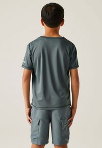 Camiseta deportiva gris de manga corta y cuello redondo, combinada con pantalones cortos cargo a juego que cuentan con dos bolsillos frontales. Tejido suave y ligero.