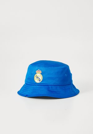 Blue bucket hat made of textured fabric, featuring a prominent yellow and gold Real Madrid logo on the front, with embroidered accents.