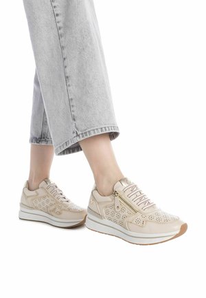 Zapatillas de cuero beige con diseño perforado, detalles en dorado y suela blanca gruesa. Cordones en varios colores y cremallera lateral funcional.