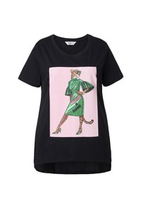 Czarny bawełniany T-shirt z wyrazistym różowym kwadratowym nadrukiem przedstawiającym lamparta w zielonej sukience, okularach przeciwsłonecznych i wysokich obcasach.