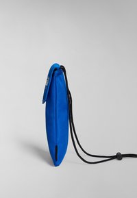 Blå tygpåse med en slät yta, utrustad med en svart justerbar snodd och en klaffstängning. Strömlinjeformad, avlång form och minimalistisk design.