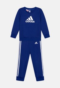 Blaues sportliches Trainingsanzug aus weichem Material, bestehend aus einem Sweatshirt mit Rundhalsausschnitt und weißem Adidas-Logo sowie passenden Hosen mit weißen Seitenstreifen.