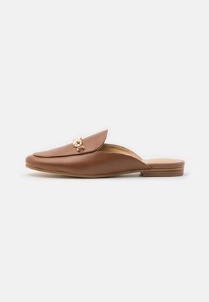 Brun læder loafers uden hælkappe med guldfarvet metalknap og lav stablet hæl, sidevisning på hvid baggrund.