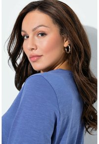 Maglia blu con taglio comodo, caratterizzata da una scollatura rotonda e maniche lunghe, evidenziata da una texture morbida e un motivo mélange sottile.