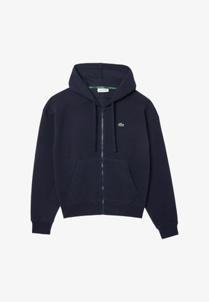 Sweatshirt navy com fecho, feito de tecido macio, apresentando um capuz com cordão, bolsos frontais e um pequeno logótipo bordado no peito.
