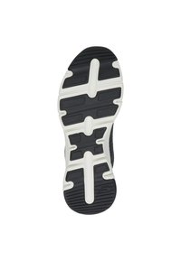 Semelle de sneaker noire en caoutchouc avec des accents blancs, présentant un motif de tacheté texturé et des rainures pour la traction.