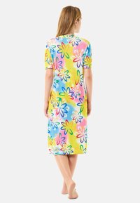 Camisón con estampado floral colorido en tejido ligero, presenta mangas cortas, diseño hasta la rodilla, con tonos de rosa, azul y amarillo.