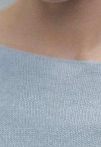 Light gray knitted sweater with a wide neckline and subtle ribbed texture, showing soft fibers and a smooth finish.