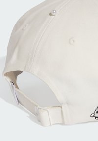 Gorra de béisbol blanca de algodón con detalle bordado, visera curva, correa ajustable y acentos de botón en la corona. Tela texturizada.