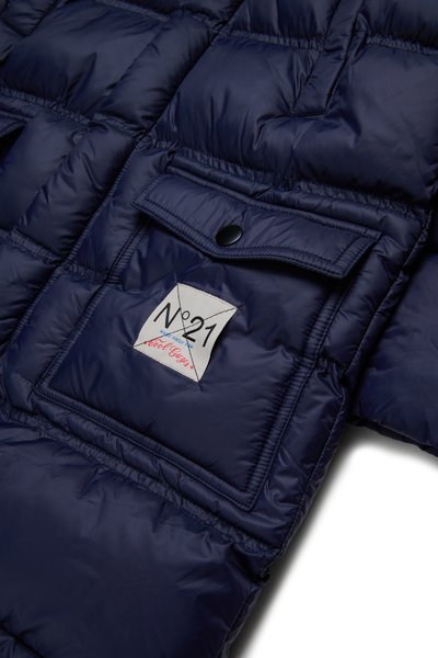 Chaqueta acolchada azul marino con textura de acolchado, que presenta un bolsillo en el pecho con una etiqueta que muestra "N°21" y solapa abotonada.