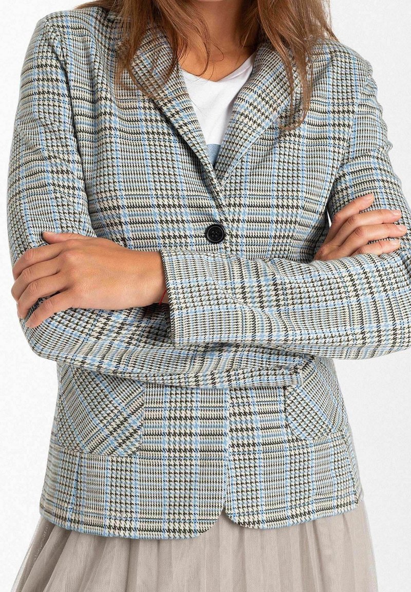 Blazer i et lysblåt og beige terningmønster, med en enkelt sort knap, to frontlommer og en skræddersyet pasform med krave.