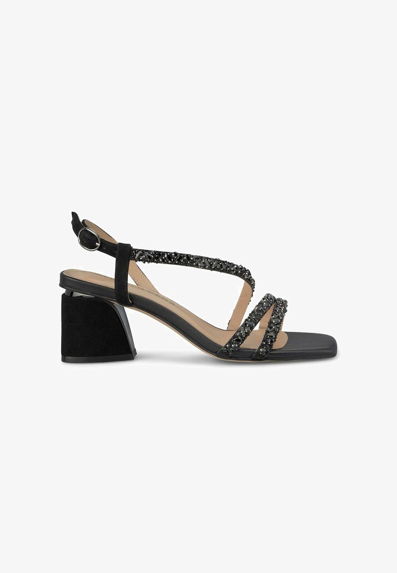 Schwarze Wildledersandalen mit Blockabsatz, ausgestattet mit über Kreuz verlaufenden Riemen, die mit schwarzen Verzierungen geschmückt sind, sowie einem Hinterriemen mit einer runden Schnalle.