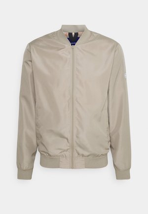 Béžová bomber bunda na zip s žebrovaným límcem, manžetami a lemem, zobrazená na bílém pozadí.