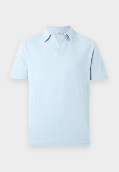 Ανοιχτό μπλε πόλο με κοντά μανίκια, γιακά και V-σχήματος άνοιγμα στη λαιμόκοψη, απεικονίζεται σε απλό λευκό φόντο.