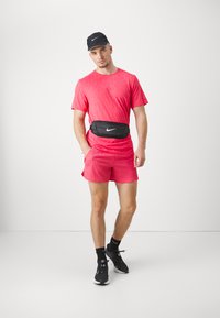 Nike Performance RISE RUN - Sports T-shirt - aster pink