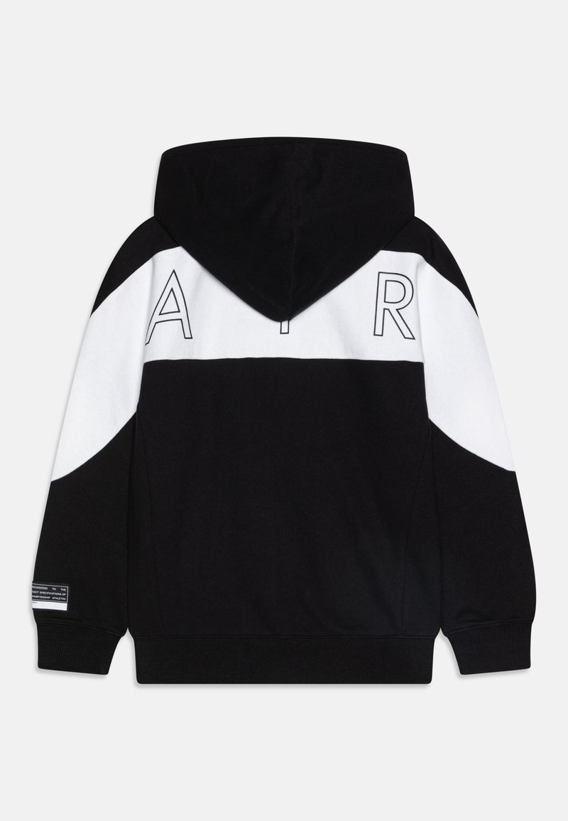 Schwarzer und weißer Kapuzenpullover mit den Buchstaben "A" und "R" in Weiß auf der Rückseite, weicher Texturierung und gerippten Bündchen.