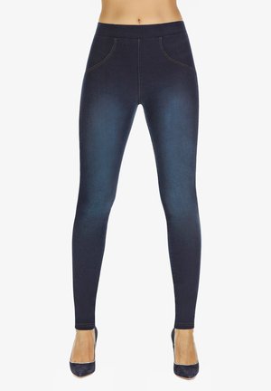 Granatowe, elastyczne legginsy o gładkiej fakturze, z wysokim pasem, sztucznymi kieszeniami i zwężanym krojem, noszone z wysokimi obcasami.