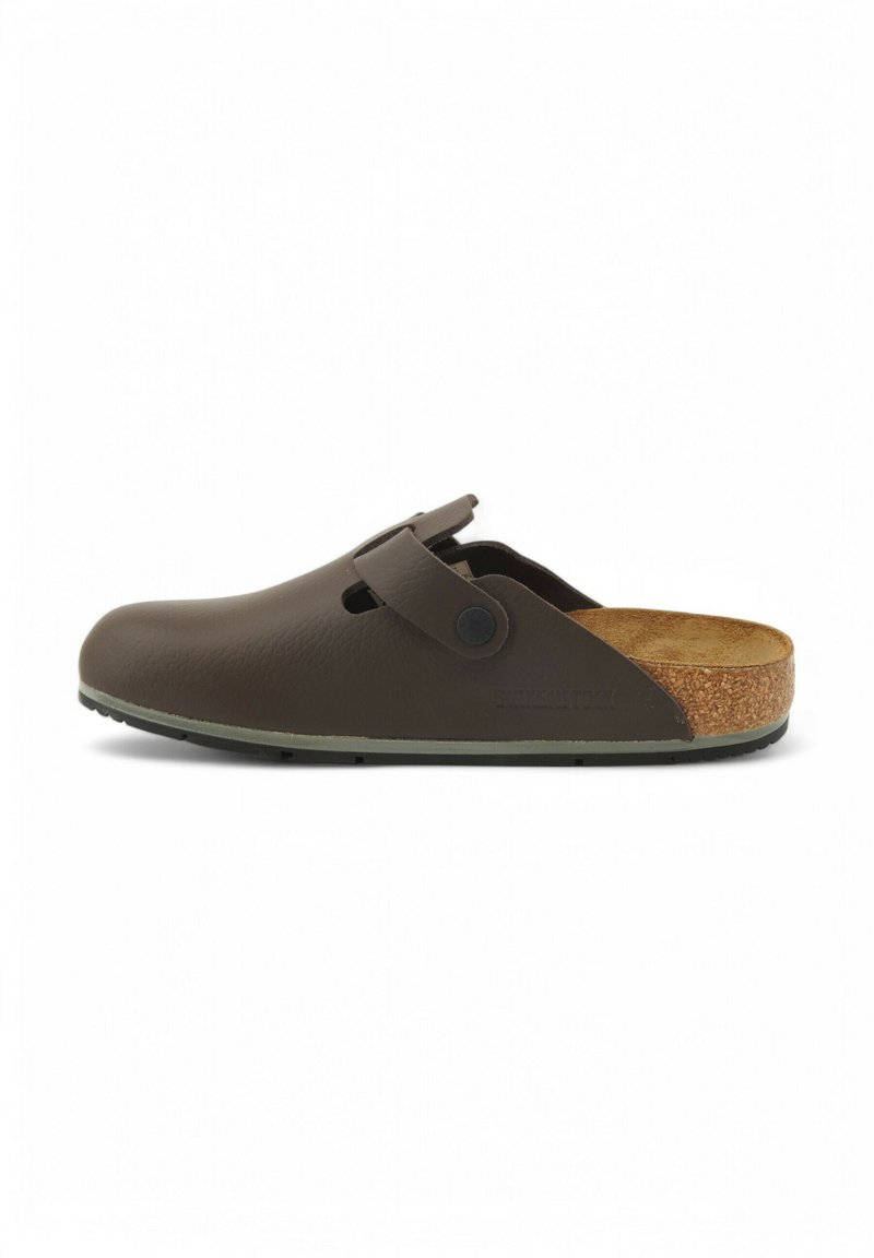 Zoccolo in pelle marrone con forma arrotondata, apertura sul retro, cinturino regolabile e soletta in sughero. Superficie testurizzata con dettagli minimi.