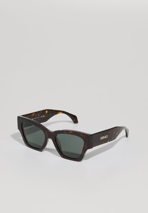 Okulary przeciwsłoneczne w stylu tortoise z kwadratowymi oprawkami, zielonymi szkłami i złotym logo "VERSACE" na zausznikach. Gładkie, błyszczące wykończenie.
