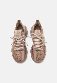 Baskets marron clair avec une tige en maille texturée, des lacets contrastants et des étiquettes de logo, dotées d'une épaisse semelle rembourrée pour un soutien.