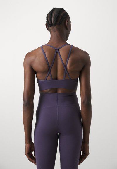 Lillaidid sports-bh og leggings med tettsittende design. BH-en har kryssede stropper på baksiden. Glatt, elastisk materiale med matt overflate.