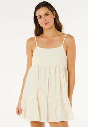 Abito estivo color beige chiaro con spalline sottili, corpetto aderente e gonna svasata a balze. Il tessuto presenta un motivo testurizzato sottile.