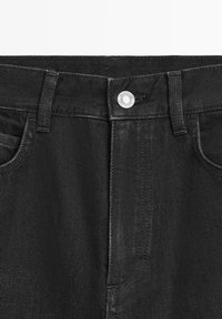 Schwarze Jeans aus Denim mit Knopfverschluss, fünf Taschen und klassischem schmal zulaufendem Schnitt. Der Stoff hat eine glatte Textur mit dezentem Ausbleichen.