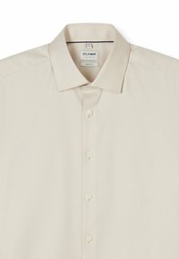 Beige Hemd mit Muster und klassischem Kragen, aus strukturiertem Stoff gefertigt und mit fünf Knöpfen auf der Vorderseite zum Schließen.