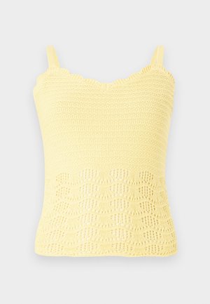 Sárga kötött trikó, hullámos széllel és textúrált mintával, nyitott szövésű részletekkel az alján. Állítható pántokkal.