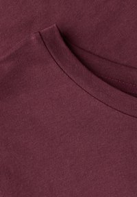 Burgundská bavlněná tričko s kulatým výstřihem, hladkou texturou a detaily na bočních švech. Detailní pohled na látku a konstrukci límce.