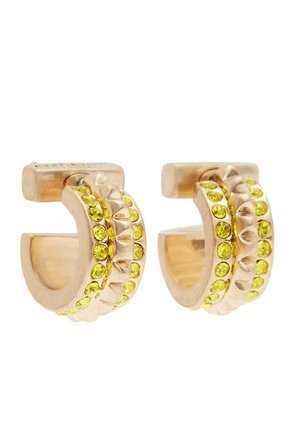 Boucles d'oreilles créoles en or avec deux rangées de petites pierres précieuses rondes jaune-vert et une bande centrale texturée.