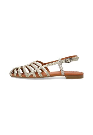 Flad sandal med flettede beige remme, åben tå, lav hæl og justerbar ankelspænde, vist i venstre sideprofil på hvid baggrund.
