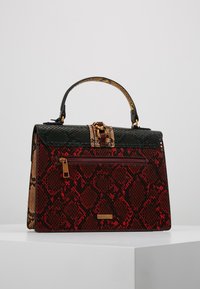 Bolso estructurado con un estampado de serpiente texturizado en rojo y negro. Cuenta con un cierre en tono dorado, asa superior y un bolsillo frontal con cremallera.