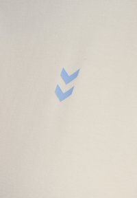 Tissu beige clair avec un motif logo en zigzag bleu clair, présentant une texture lisse et un subtil motif côtelé.