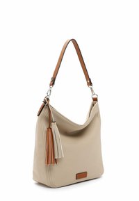 Bolso de hombro de cuero beige con un diseño curvado, correa de acento marrón y borlas multicolores. Presenta una textura suave y un branding sutil.