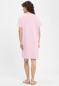 Rosa Baumwoll-T-Shirt-Kleid mit kurzen Ärmeln, Rundhalsausschnitt und geradem Schnitt, der knapp über dem Knie endet. Sanfte Textur und schlichtes Design.